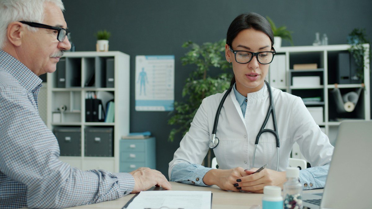 Eye doctor consulting with a patient and reviewing clinical scan findings in consultation room